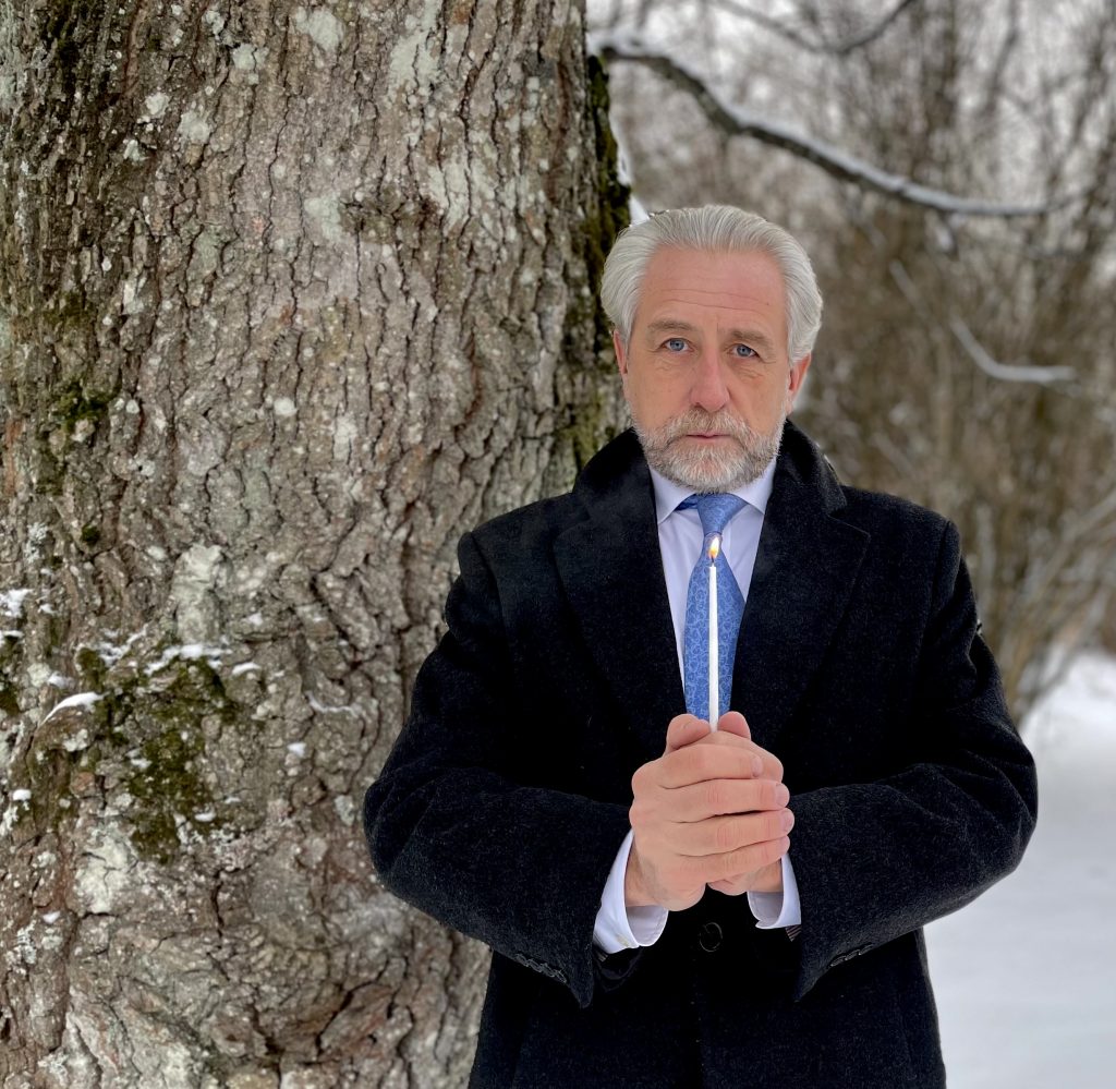 An image of Dag Hammarskjöld Foundation Executive Director Henrik Hammargren holding a candle to commemorate International Holocaust Remembrance Day.